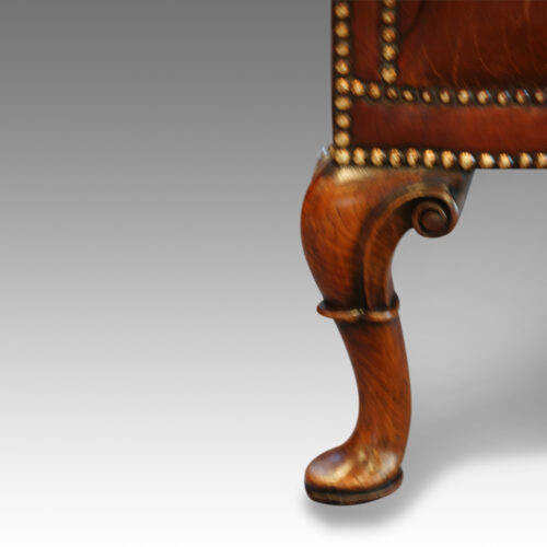 Queen Anne style walnut and leather wing chair front leg