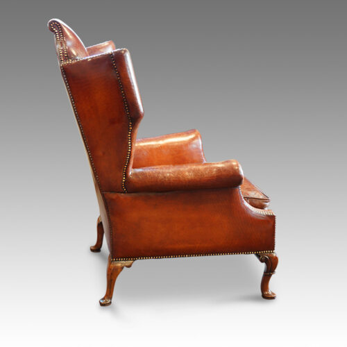 Queen Anne style walnut and leather wing chair side view