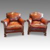Pair of Edwardian club chairs with claw and ball feet