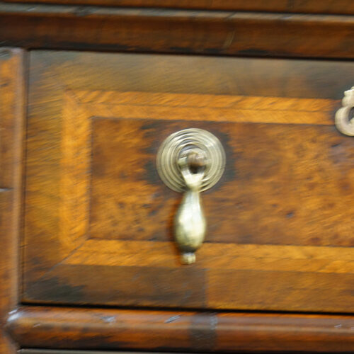 Brass drop handle on antique chest on stand