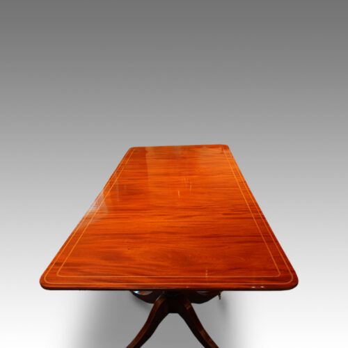 Regency style twin pillar mahogany dining table with line inlay end view