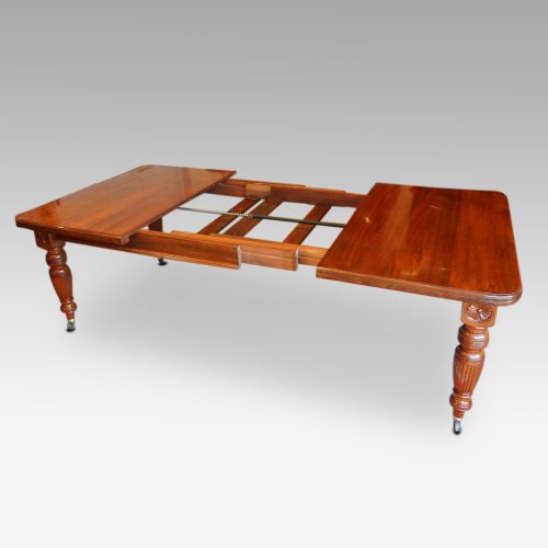 Edwardian walnut extending dining table, by Hampton & sons showing runners