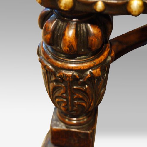 Pair of oak and leather wing chairs carving detail