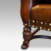 Pair of oak and leather wing chairs front leg