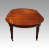Edwardian mahogany circular extending dining table end view