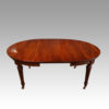 Edwardian mahogany circular extending dining table with one leaf