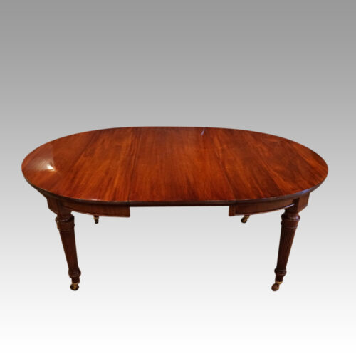 Edwardian mahogany circular extending dining table with one leaf