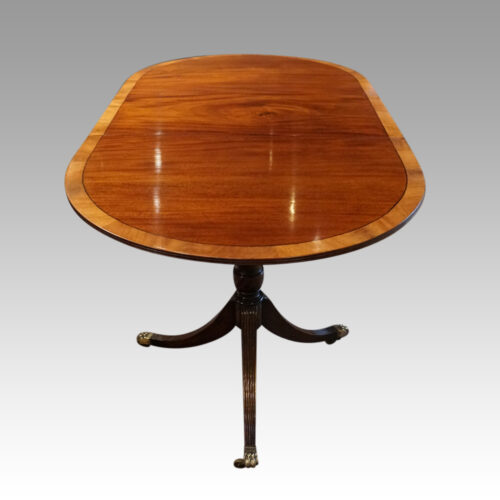 Regency style mahogany deep banded dining table end view