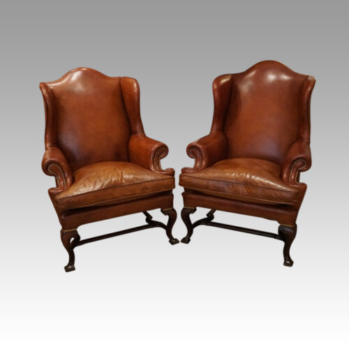 Pair of Georgian style leather wing chairs at angle