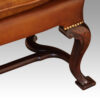 Pair of Georgian style leather wing chairs front leg