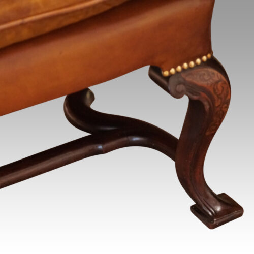 Pair of Georgian style leather wing chairs front leg