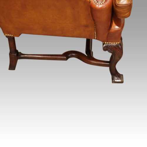 Pair of Georgian style leather wing chairs stretcher