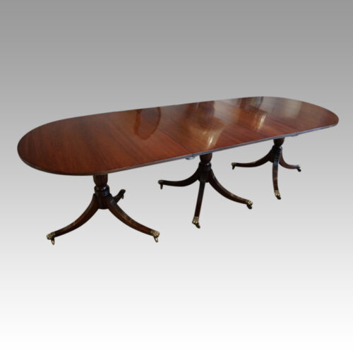 George III mahogany triple pillar dining table at angle
