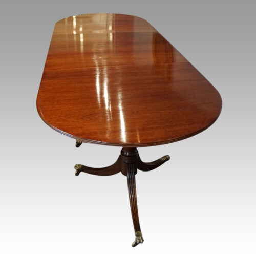 George III mahogany triple pillar dining table view of end