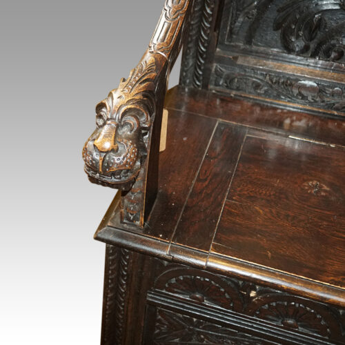 Victorian carved oak settle arm detail