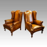 Pair of Edwardian leather wing chairs angled
