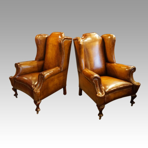 Pair of Edwardian leather wing chairs angled
