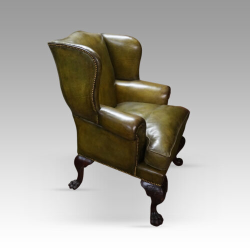 Antique Irish green leather wingchairs angle view