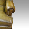 Antique Irish green leather wingchairs arm detail