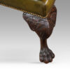 Antique Irish green leather wingchairs front leg detail