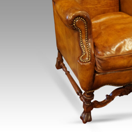Pair of walnut leather wing chairs front arm