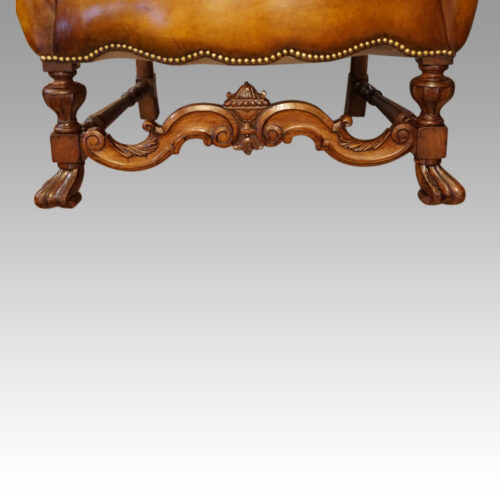 Pair of walnut leather wing chairs stretcher