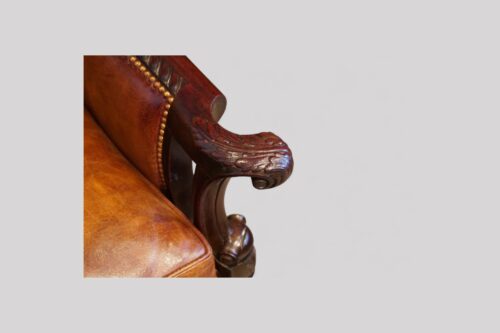 Pair of Edwardian leather club chairs hand grip