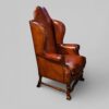 Pair of Edwardian leather wing back chairs angle
