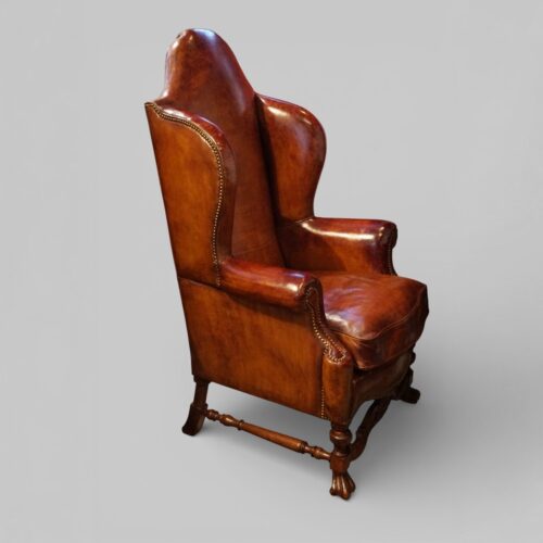 Pair of Edwardian leather wing back chairs angle