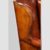 Pair of Edwardian leather wing back chairs wing detail