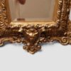 Large antique gilt trapezoidal mirror with elaborate carved ornamental frame