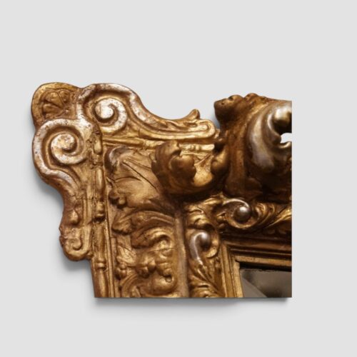 Antique gilt and silver-gilt trapezoidal mirror with ornate decorative frame