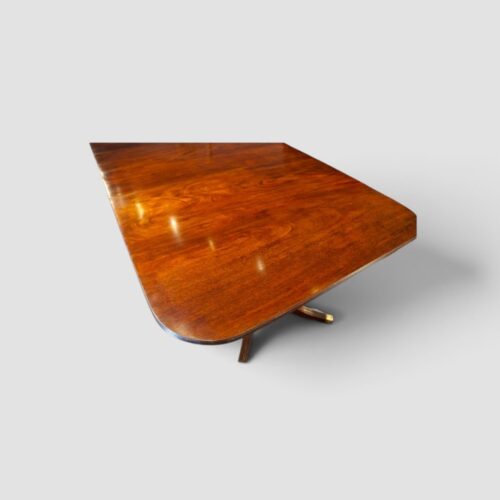 Early 20th-century Regency style extending dining table with twin pedestal supports.