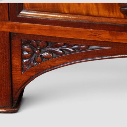 Elegant antique Holland & Sons library writing table with figured mahogany, carved details and brass castors.
