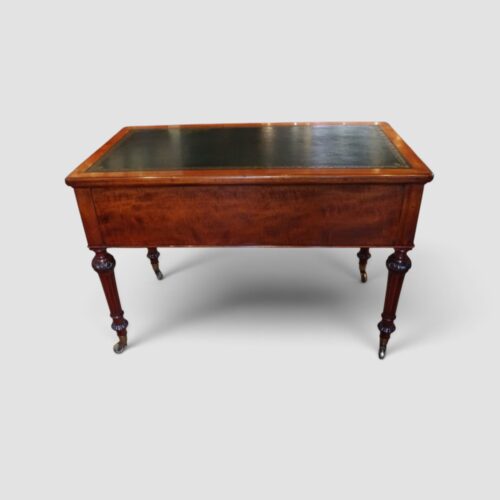 Antique Victorian mahogany partner's writing desk by Holland & Sons standing on carved turned legs with brass castors.